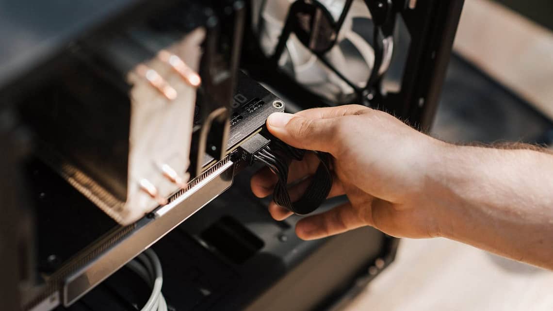 crop faceless man inputting cables in system unit